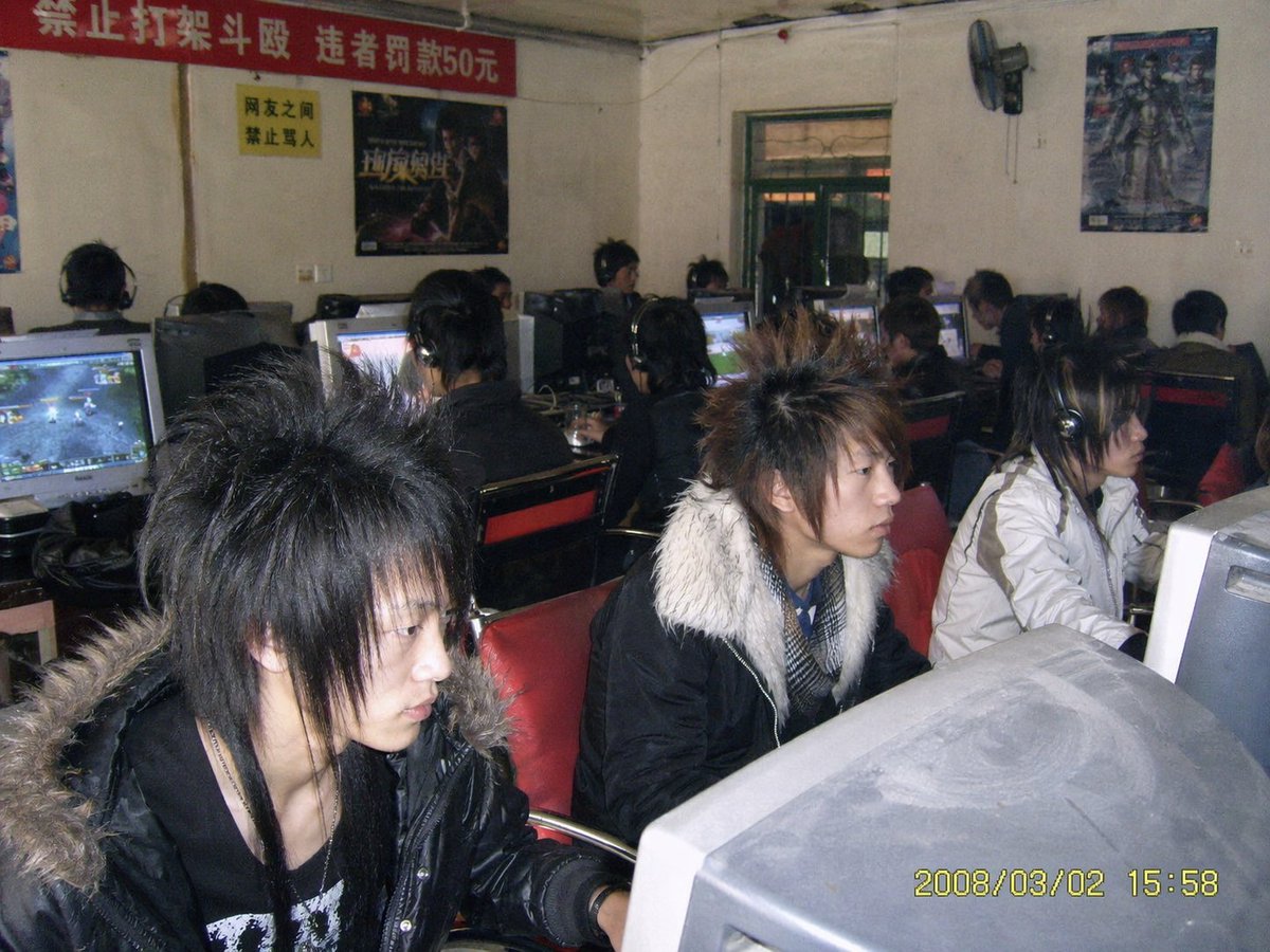 Generate an old photo of a {argument name="location" default="small-town internet cafe"} in China from {argument name="…