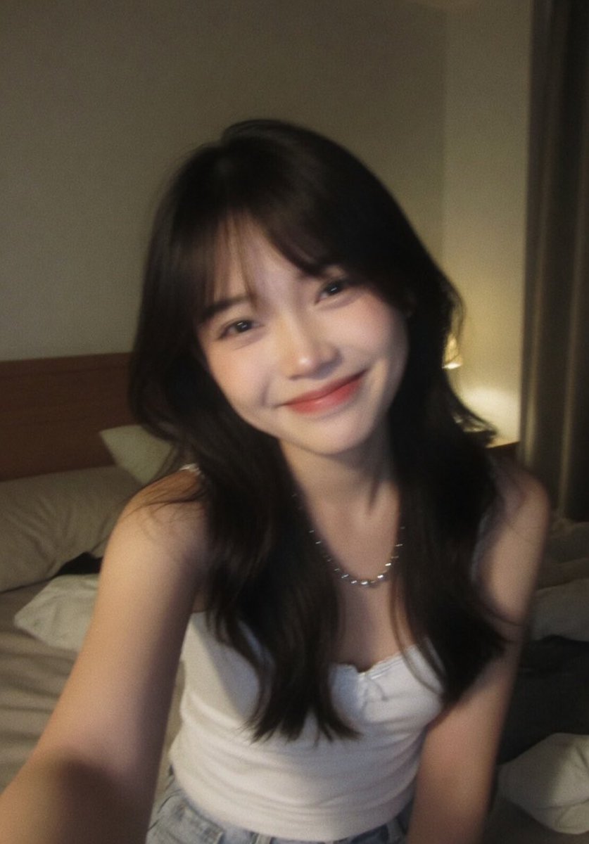 Create a candid front-facing smartphone selfie of {argument name="subject" default="a young Asian woman"} sitting on an…
