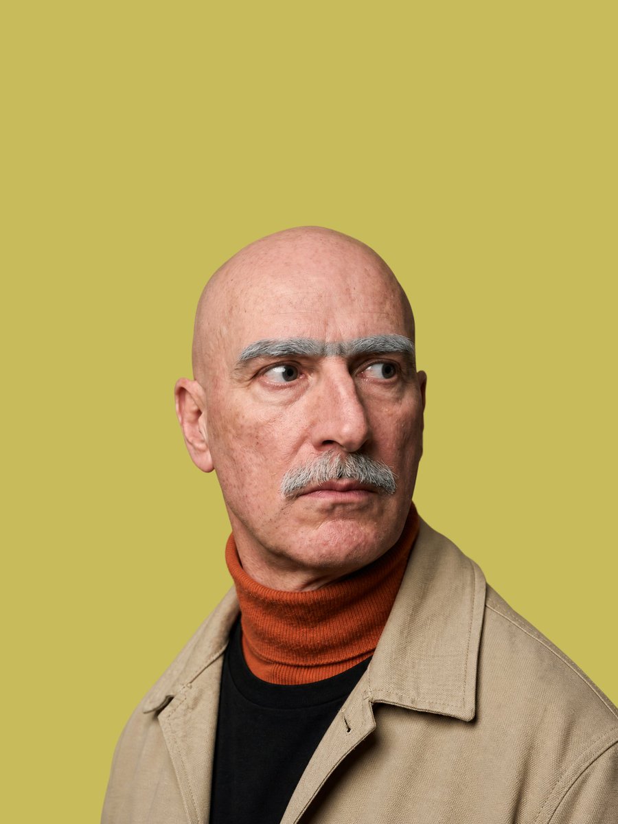 Create a realistic studio portrait of {argument name="subject" default="a bald middle-aged man"} from the chest up, cen…