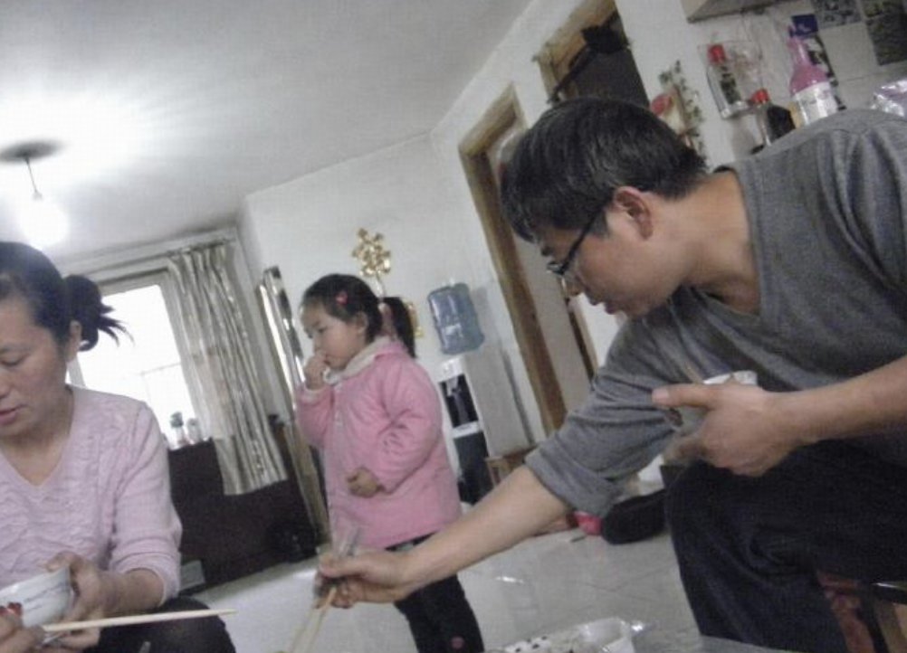 Create a low-resolution, candid indoor family snapshot with an unsettling hyper-realistic AI-photo feel, shot at a slig…
