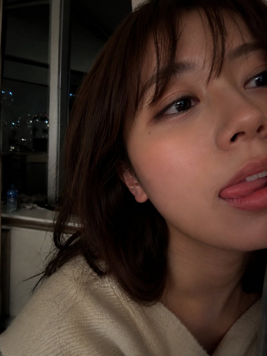 Ultra-realistic close-up selfie portrait of a {argument name="subject" default="young woman"} indoors at night, capture…